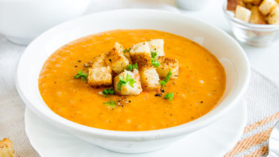 skål med gulrotsuppe og krutonger